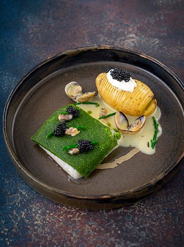 Tarbot met kruidenkorst met hasselback-aardappelen, venusschelpen en botersaus