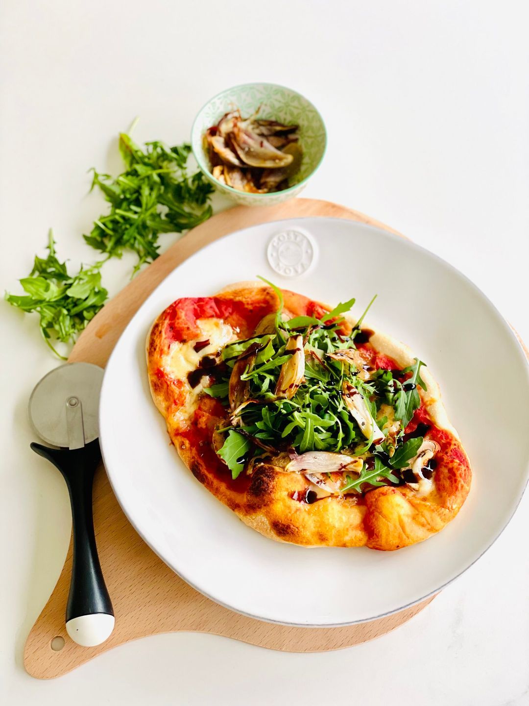 Pizza met geroosterde sjalot, rucola en balsamicocrème