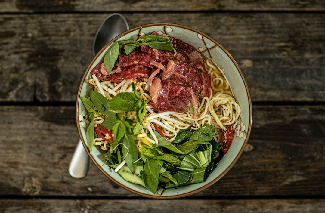 Vietnamese noodlesoep met rauwe wagyu slices en paksoi